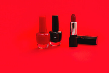 Red and black nail polish, red lipstick isolated on red background. Beauty, fashion, care concept.