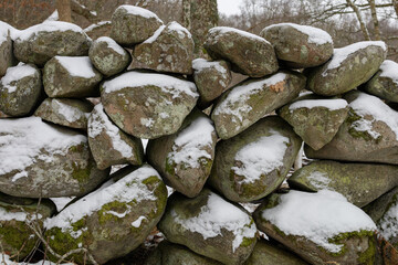 Stone boulder fence covered with snow somwhere inSweden, Europe