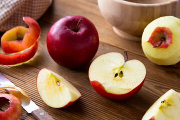 Red apples slices on wooden rustic table.