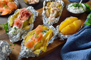 Variation gefüllter Ofenkartoffeln : mit Lachs, mit Shrimps und mit Parma-Schinken und Kräuterquark  - Various kinds of baked potatoes with herb sour cream: topped with salmon, Italian ham and shrimps