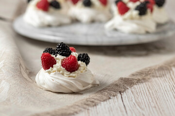 Pavlova cake. The cakes are on a marble platter. Sweet Dessert. A treat for guests. Dessert for the holiday. Cake decorated with berries.