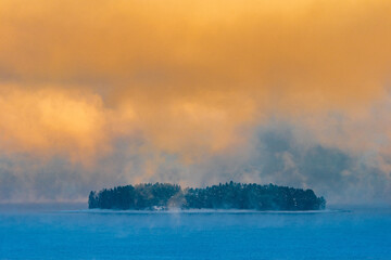 Hovinsholmen Island in Lake Mjøsa with frost smoke during winter.