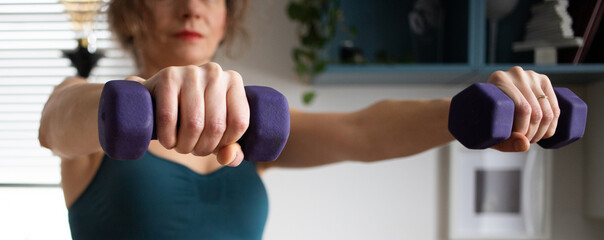 woman doing exercise at home focus on dumbells