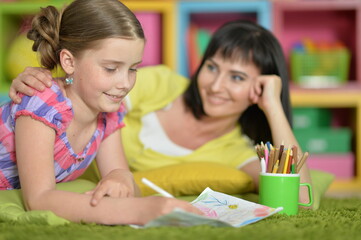 happy girl with mother drawing at home