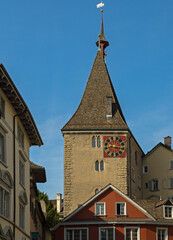 Fototapeta premium Tower with a red clock on Neumarkt Street in the Rathaus quarter of Zurich, Switzerland