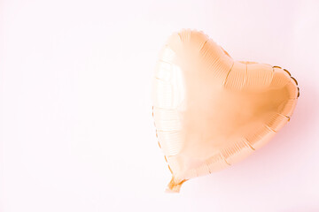 Fototapeta premium a ball of gold foil on a yellow background. Valentine's Day. The heart.