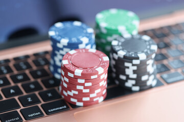 On laptop keyboard are colorful casino chips