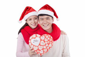 Portrait of young couple wearing Santa hats,holding gift