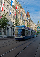 Fototapeta na wymiar A blue tram traveling along an iconic shopping street in Zurich, Switerland