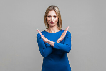 There is no way. Portrait of woman in elegant blue dress standing with sceptic smile and crossing...
