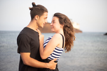 Beautiful couple in love, boyfriend and girlfriend look at each other smiling during their engagement vacation