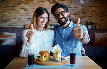 Young couple sitting in a cafe, having breakfast. Love, dating, food, lifestyle concept