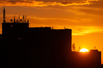 Wschód słońca nad industrialnym budynkiem - obrazy, fototapety, plakaty