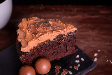 Homemade fresh bake sweet dessert organic delicious traditional dark chocolate cake layer frosting with glaze fudge salted cacao cream cheese serve with coffee tea on wooden table