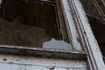 Old window frame with broken glass and peeling paint