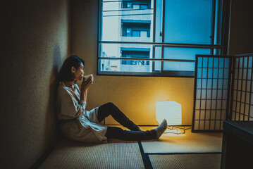 Japanese girl sits at home and drinks tea
