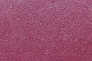 The surface of the red old worn dermatin with a small pattern.