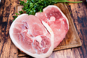 slice of fresh pork on a wooden cutting board