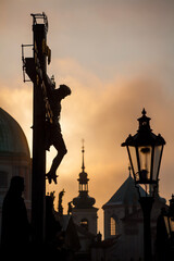 Prague cross on the charles bridge by sunrise - silhouette