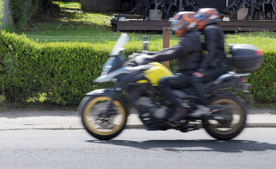 Fototapeta na wymiar Panning de motocicleta na rua com pessoas
