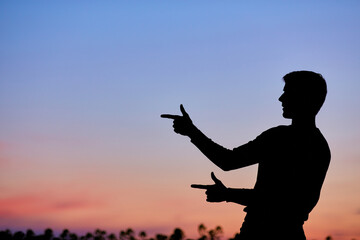 Men silhouette at sunset, human body over natural colorful sky background, hands up having fun