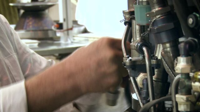 Aviation structure. Worker screwing small parts into the metal tube system