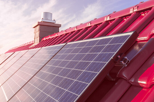 solar panels or photovoltaic power plant on a red tiled roof, renewable sun power energy 