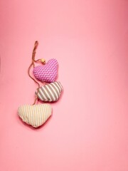 soft fabric hearts fly on a soft pink colored background, copy space. Valentine's Day concept for design