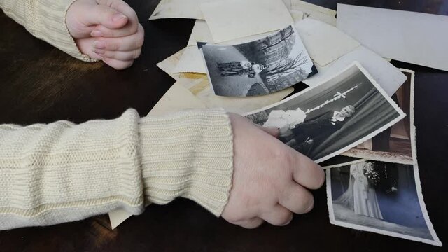 female hands holding old photographs of 1950s,