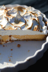 Lemon meringue pie cut in half. Selective focus.