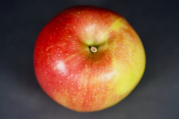 Red and green apple on black background.