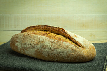 Fresh homemade bread lies on planks and fabrics