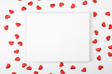 Canvas mockup with red hearts and festive decoration ribbon on a white background. Design element for Valentines Day and Mother Day congratulation, thank you, greeting or invitation card, art work