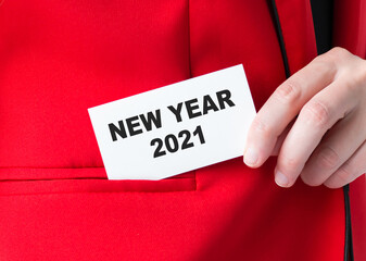 New Year 2021 inscription on the card, which the businessman puts in the pocket of the jacket