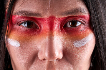 close-up eyes of indian woman confidently looking at camera, serious ethnic female with paintings on face. indian ehnicity, shaman concept - obrazy, fototapety, plakaty