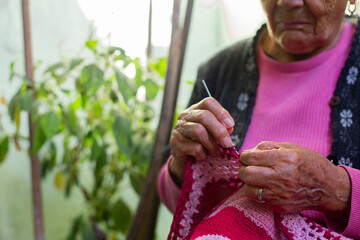 Close-Up Of The Hands Of Old Woman Knitting At Home