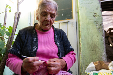 Senior Woman Knitting At Her Home