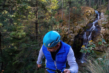 Man taking a selfie while dangling from a rope canyoning