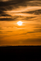 Fototapeta na wymiar A landscape of the golden sky, the silhouetted earth and the setting sun