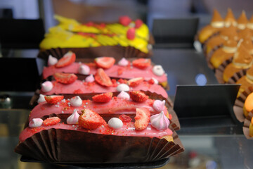 French dessert eclairs at showcase of cafe shop, traditional sweet food, selective focus