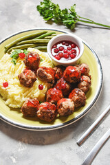 Swedish meatballs with mashed potatoes and green beans on concrete background
