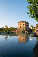 Fototapeta premium The beautiful medieval village of Borghetto di Valeggio sul Mincio. Detail of the river medieval tower with the bridge the swans and the medieval buildings. Verona, Veneto, Italy