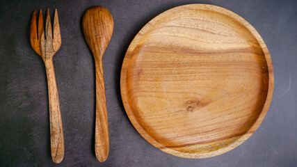 wooden empty plate on a dark stone background, a blank for design.