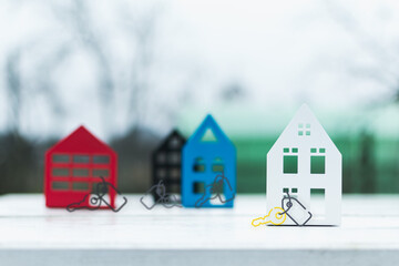 Models of houses made of metal of different colors on a decorative background of boards