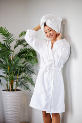 asian female touching head in towel, stand after shower, enjoying time for herself, beauty concept