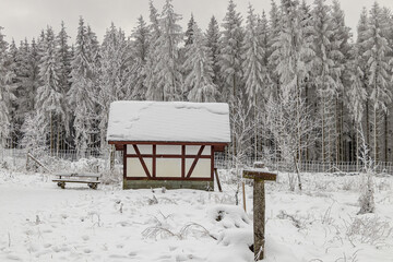 verschneite Hütten mitten im Winterwald