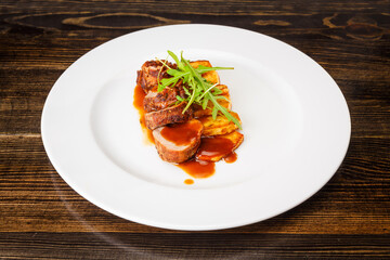 Juicy piece of grilled meat with fried potatoes and arugula