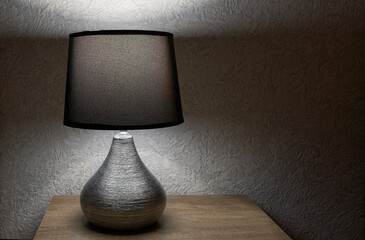 tylish lamp on table against wall, space for text.