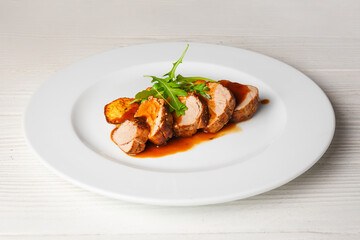 Juicy piece of grilled meat with fried potatoes and arugula