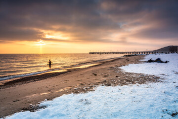 Amazing snowy beach in Gdynia Orlowo at sunrise, Baltic Sea. Poland